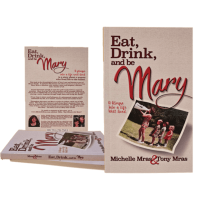 A grouping of the book Eat Drink and Be Mary. The Cover contains what appears to be mom and 4 kids marching. The title and author credit to Michelle and Tony Mras